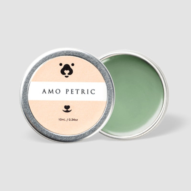 Green balm in a round metal container with 'Amo Petric' label on a light gray background