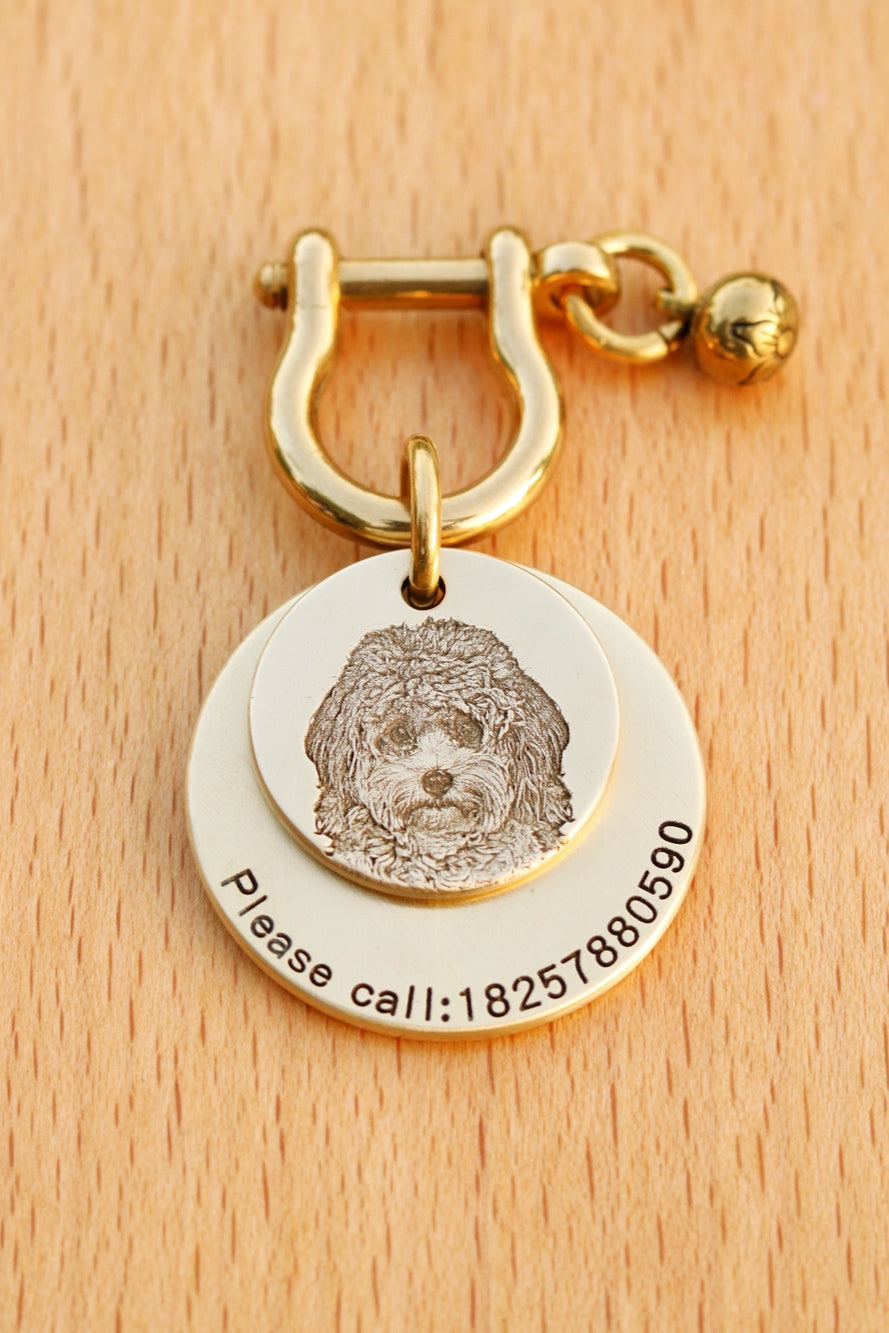 Gold keychain with dog tag and engraving on a wooden surface