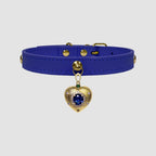 Blue leather choker with a gold heart-shaped charm on a light gray background