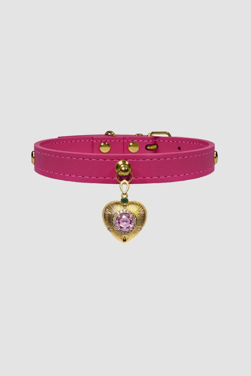 Pink choker with a gold heart-shaped charm on a light gray background