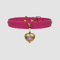 Pink choker with a gold heart-shaped charm on a light gray background
