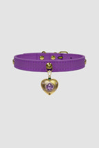 Purple choker with a gold heart-shaped charm on a light gray background