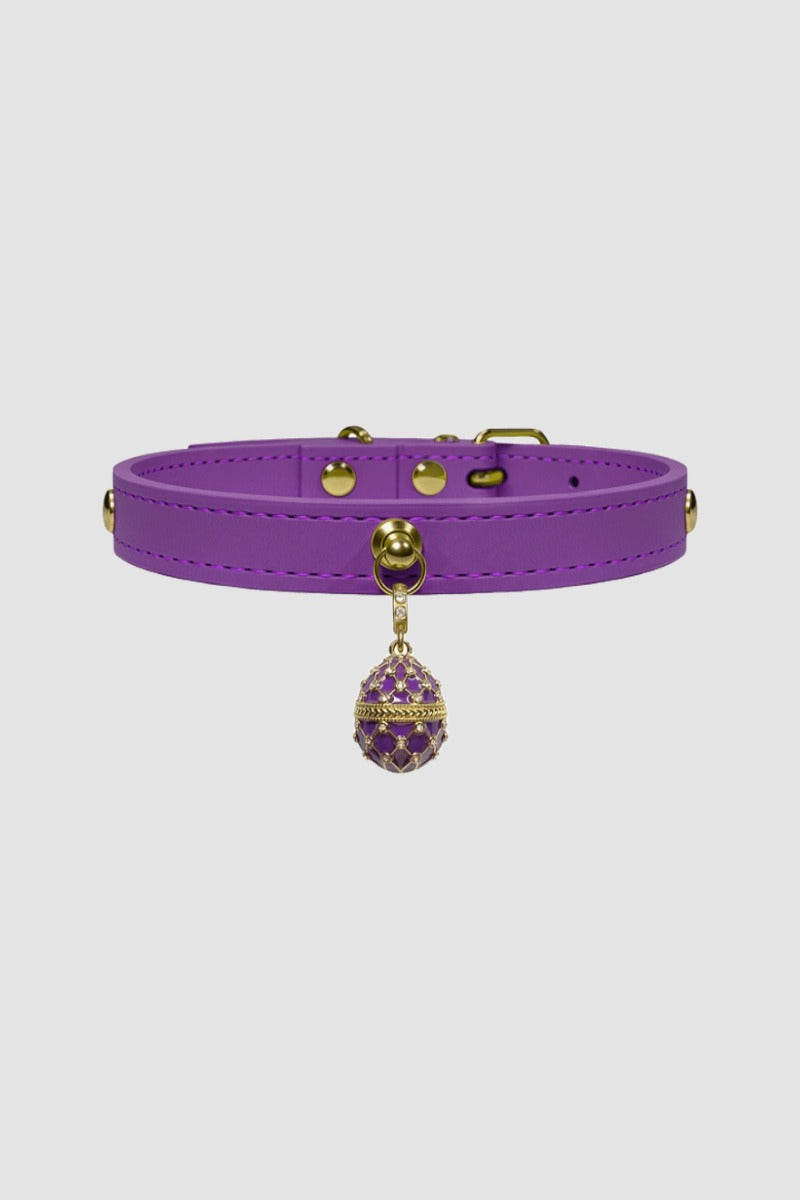 Purple leather choker with a decorative pendant on a light gray background