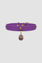 Purple leather choker with a decorative pendant on a light gray background