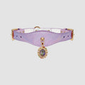 Lavender cat collar with a decorative charm on a light gray background